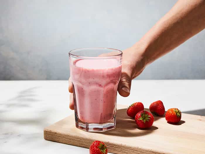 A hand grabbing a delicious smoothie