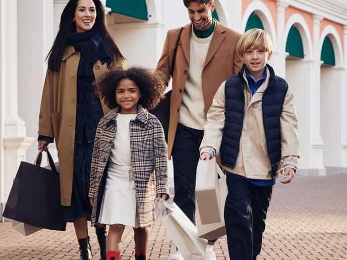 A happy family walking with shopping bags and their dog