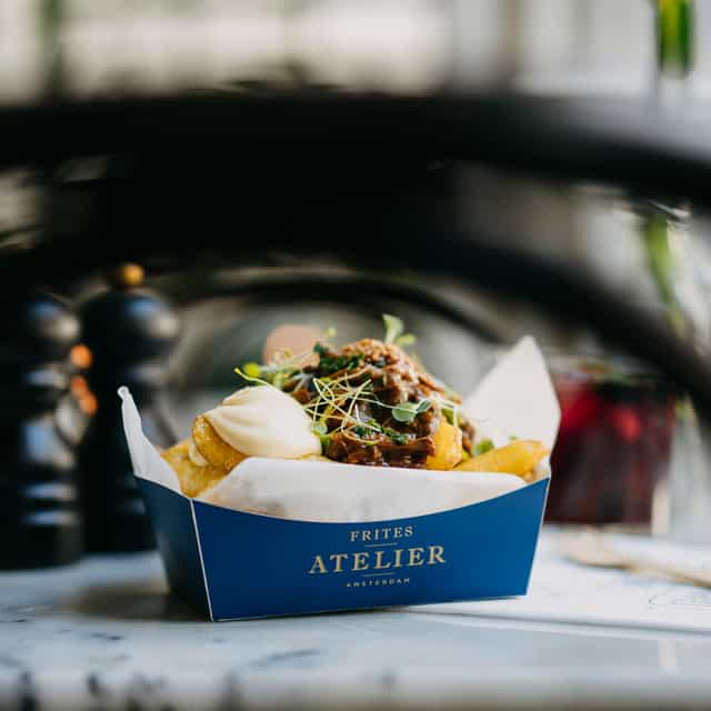 Image of fries in a box, covered by a sauce